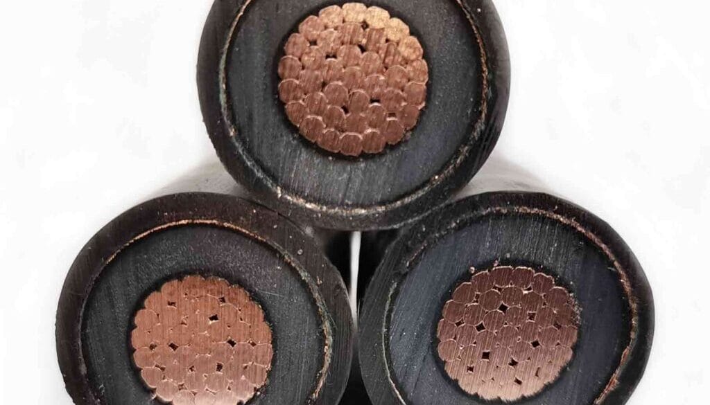 Close-up view of three thick, black electrical cables with exposed copper wire cores arranged in a triangle formation.
